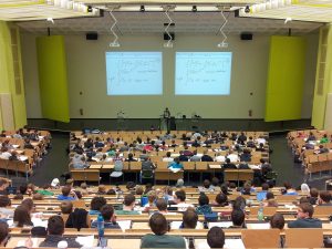 Lecture classroom full of students with instructor upfront