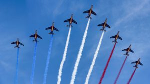 9 Jets in formation with blue, white, red smoke coming out