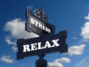 Street sign that says Stress and another sign says relax